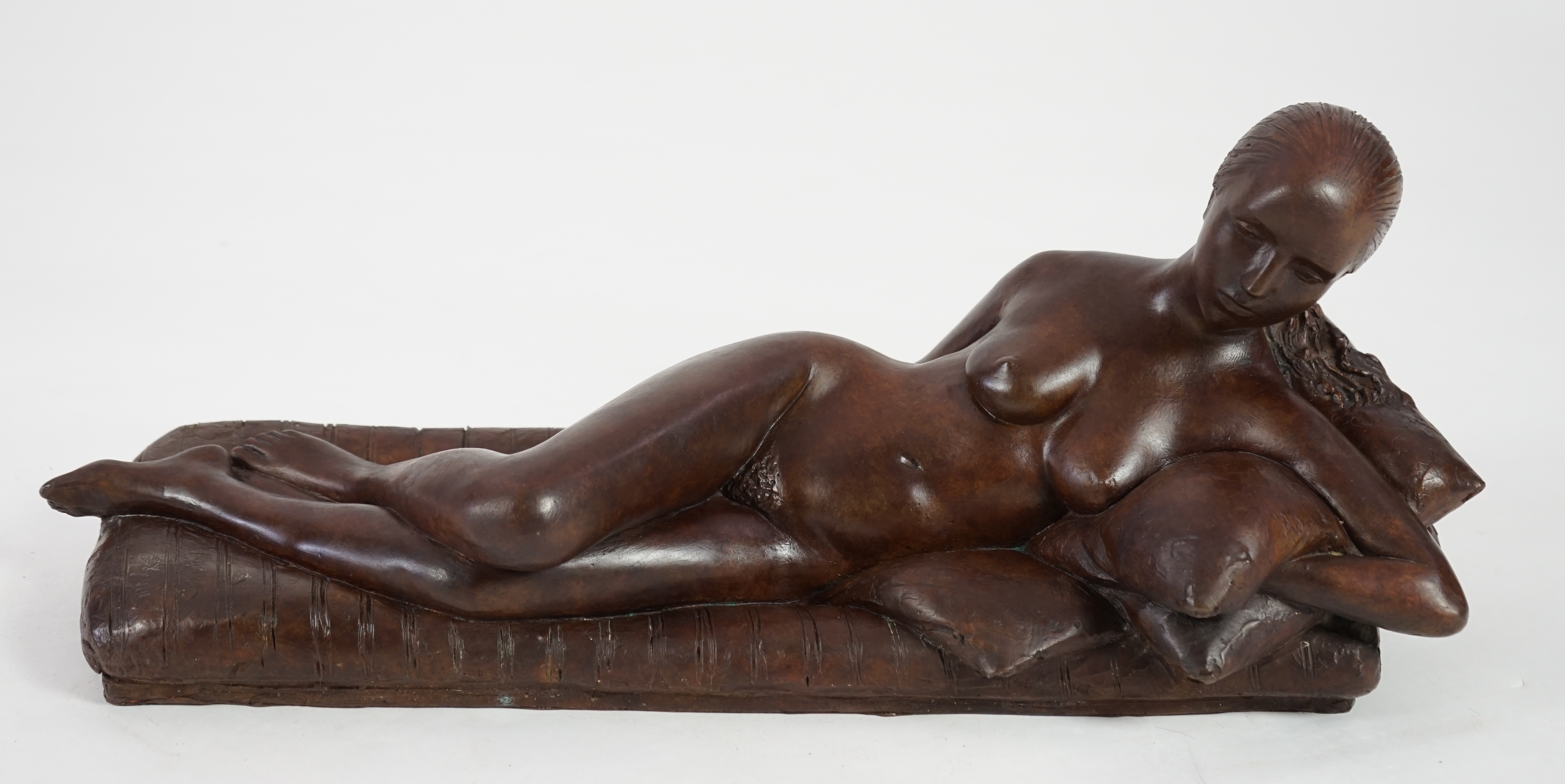 James Butler (1931-2022). A bronze figure of a female nude reclining upon cushions